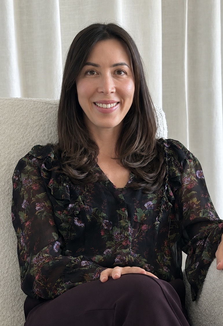 Zazie seated on a cream sofa, smiling warmly